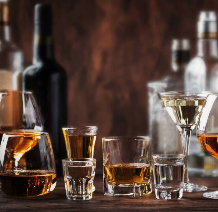 Strong Spirits Set. Hard alcoholic drinks in glasses in assortme Strong Spirits Set. Hard alcoholic drinks in glasses in assortment: vodka, cognac, tequila, brandy and whiskey, grappa, liqueur, vermouth, tincture, rum. Vintage bar counter background, selective focus